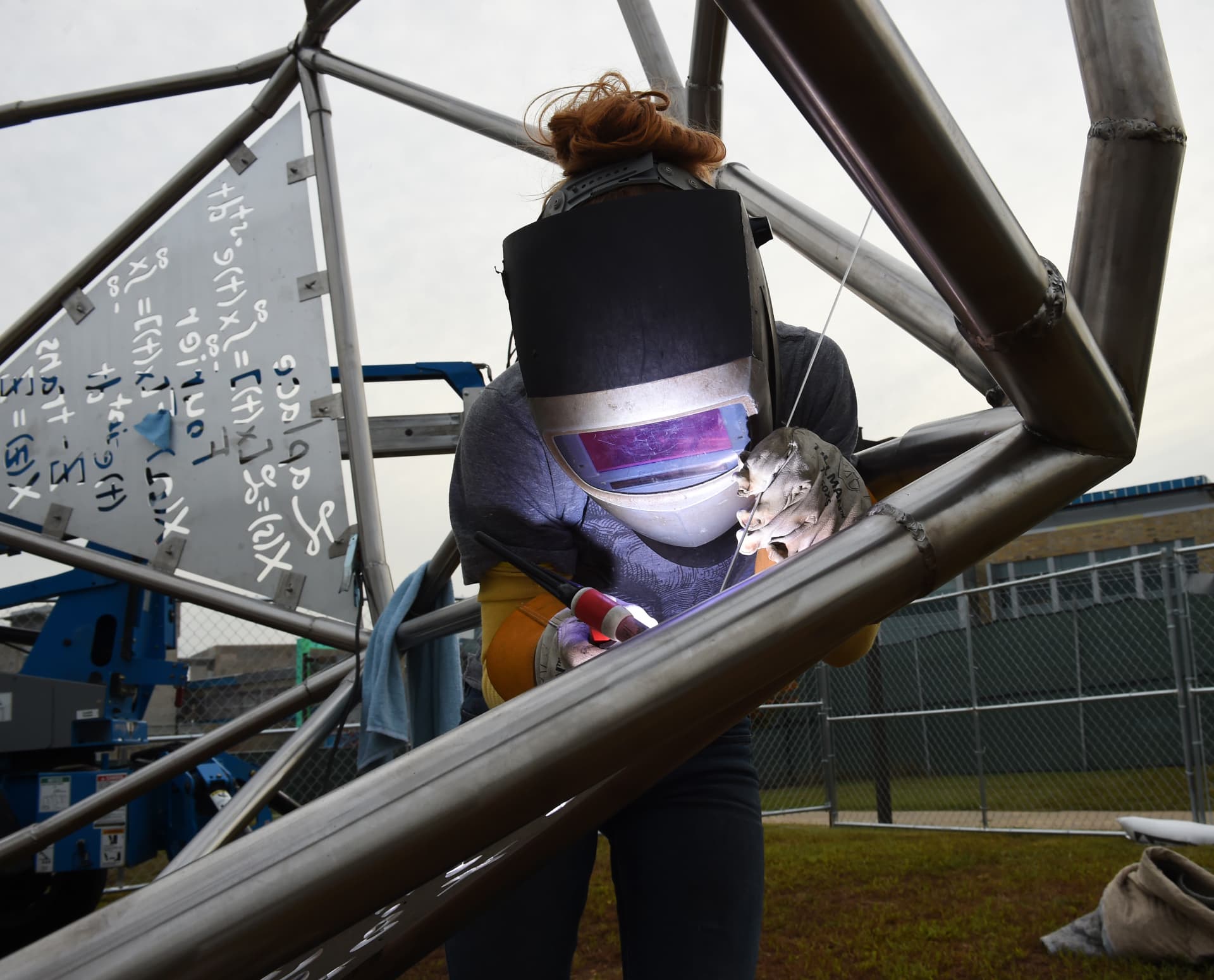 Artist welding steel on a large-scale public sculpture during fabrication